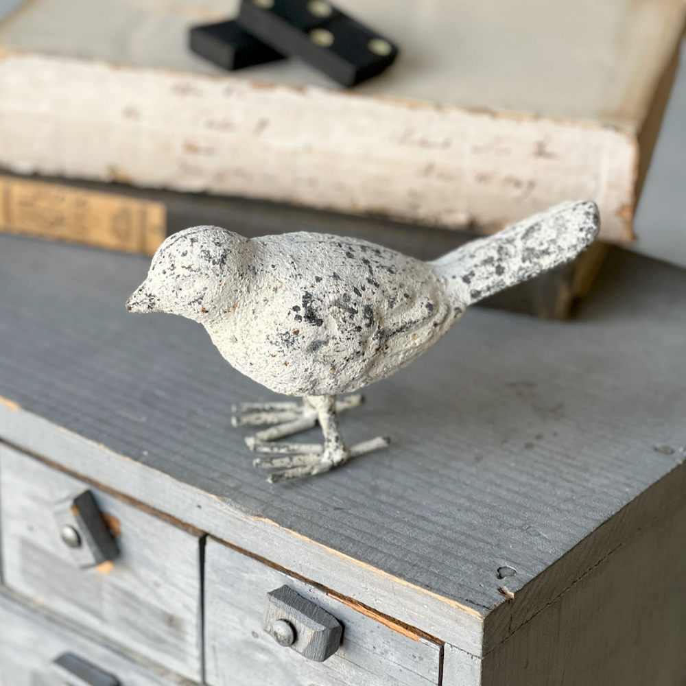 Decorative bird figurine on a wooden surface with a rustic background