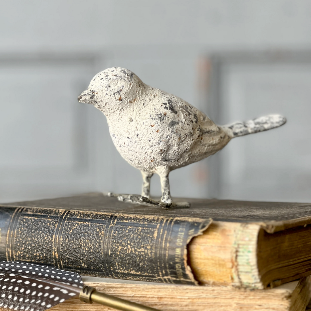 Decorative bird figurine on an old book with a blurred background