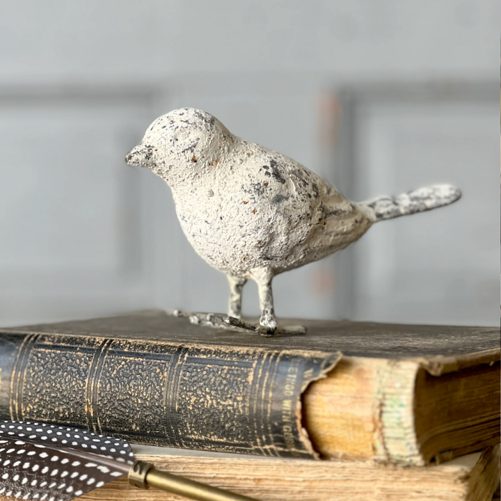 Decorative bird figurine on an old book with a blurred background