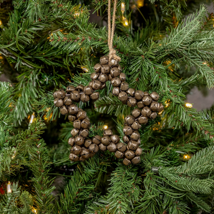 Star-shaped ornament with bells hanging on a Christmas tree