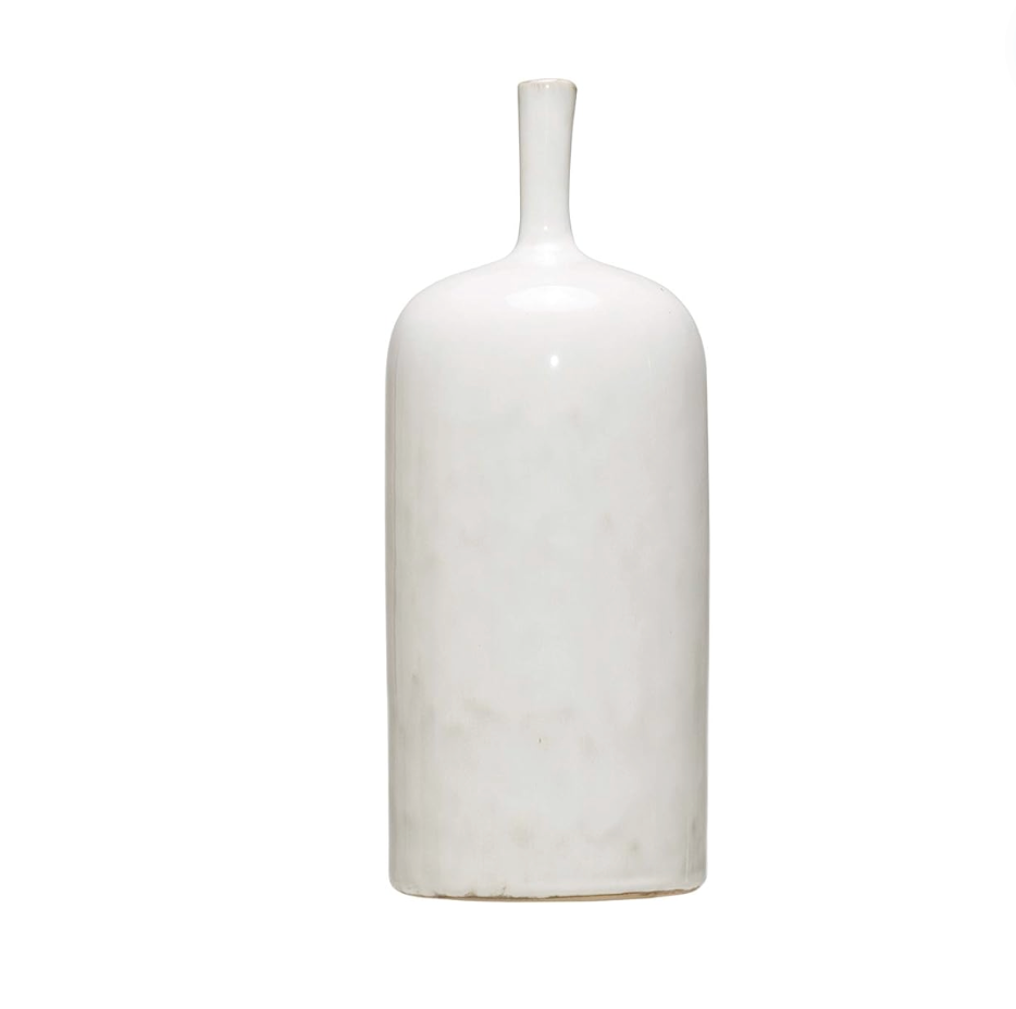 Three white stoneware vases of varying sizes arranged on a wooden surface, with the topmost vase containing a sprig of greenery.