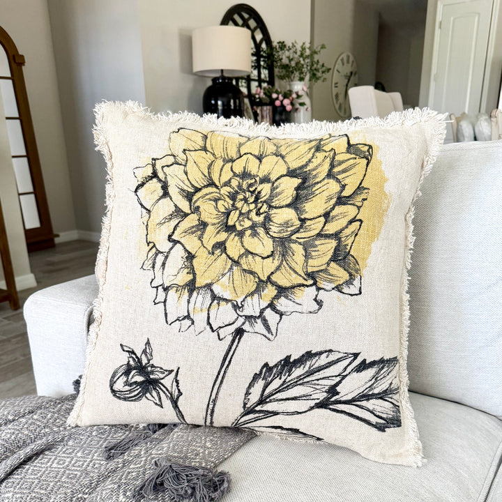 Decorative pillow with yellow floral design on a couch in a living room setting