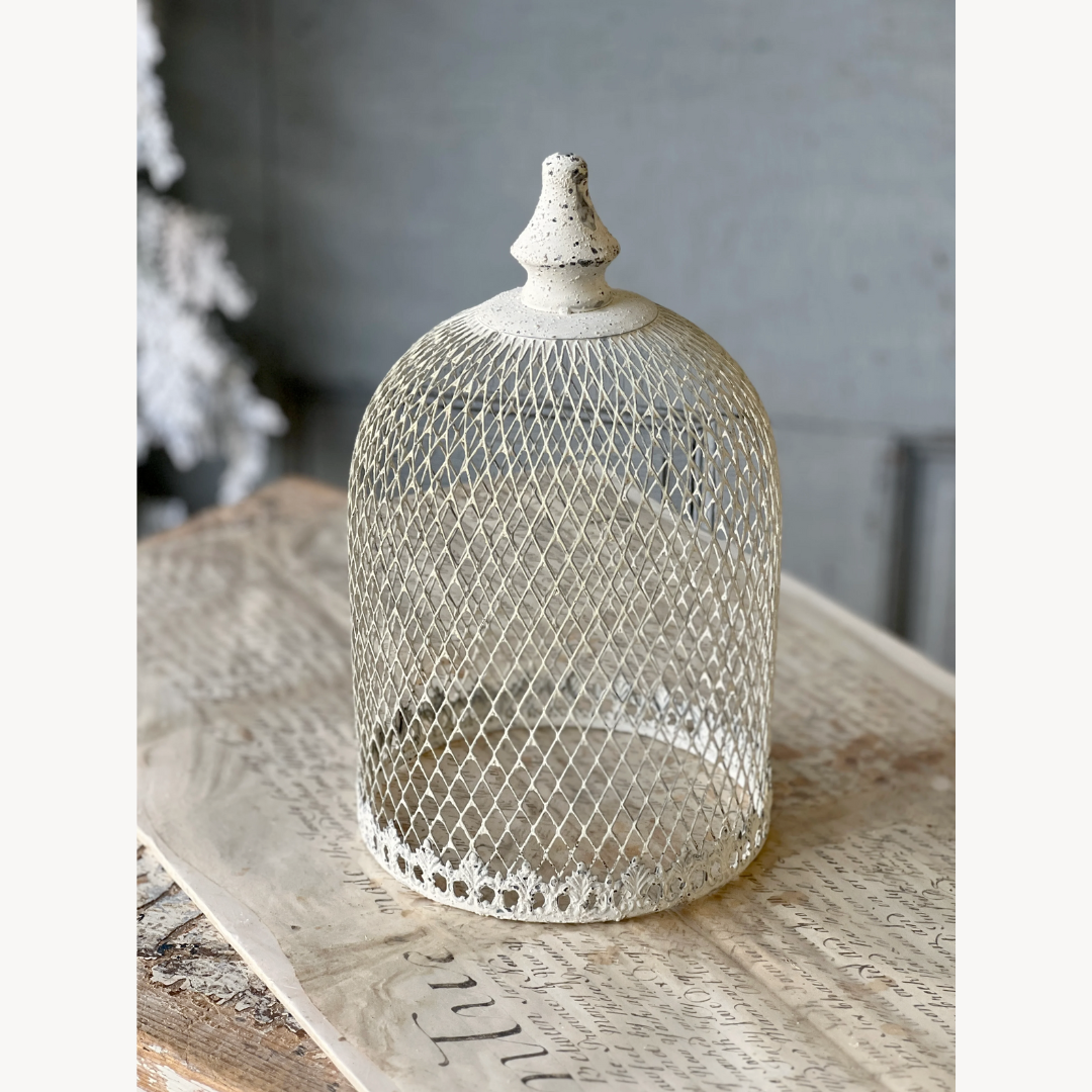 Decorative metal cloche with textured surface on a wooden surface