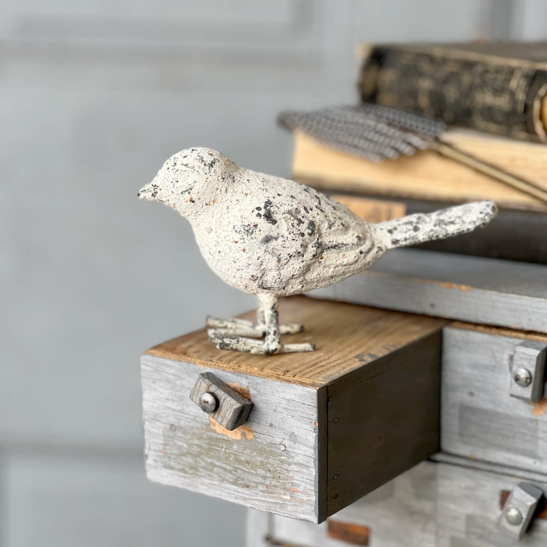 Decorative bird figurine on a wooden surface with a blurred background
