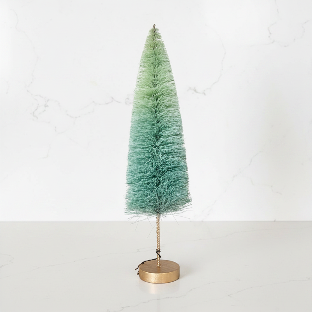 Small green artificial Christmas tree with a gold base on a white background