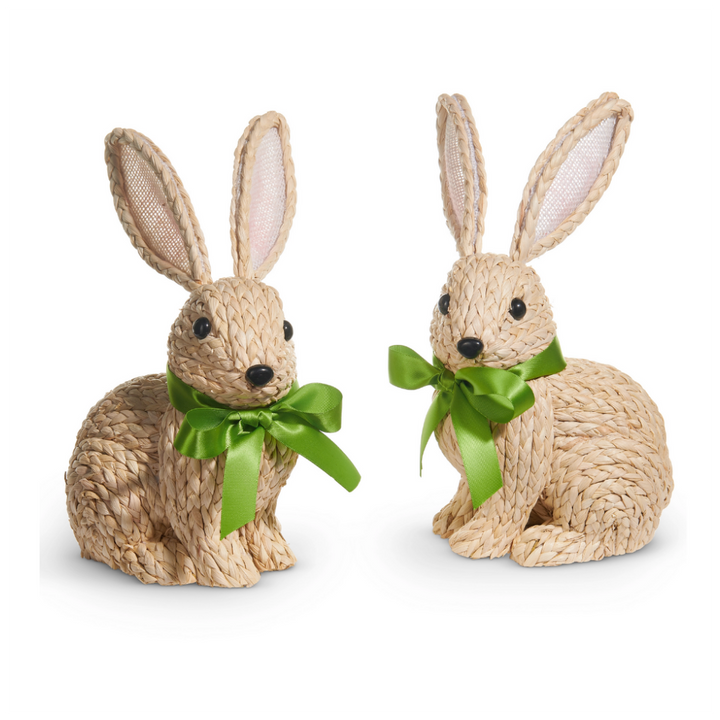 Two woven rabbit figurines with green bows on a white background