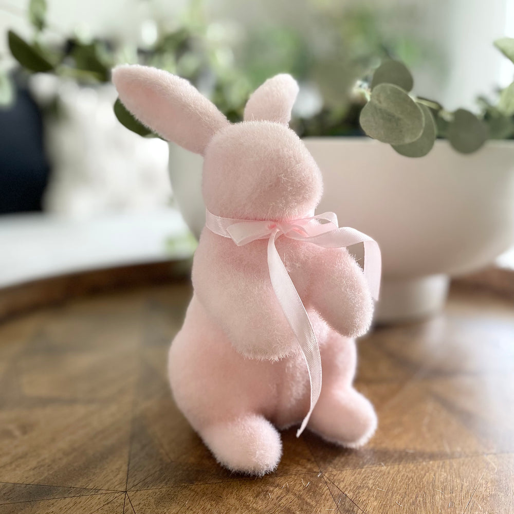 Pastel pink standing flocked bunny decorations with ribbon bows.