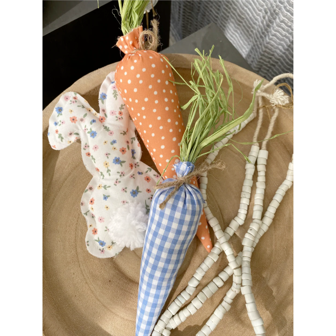 Decorative carrot and rabbit plush on a wooden surface