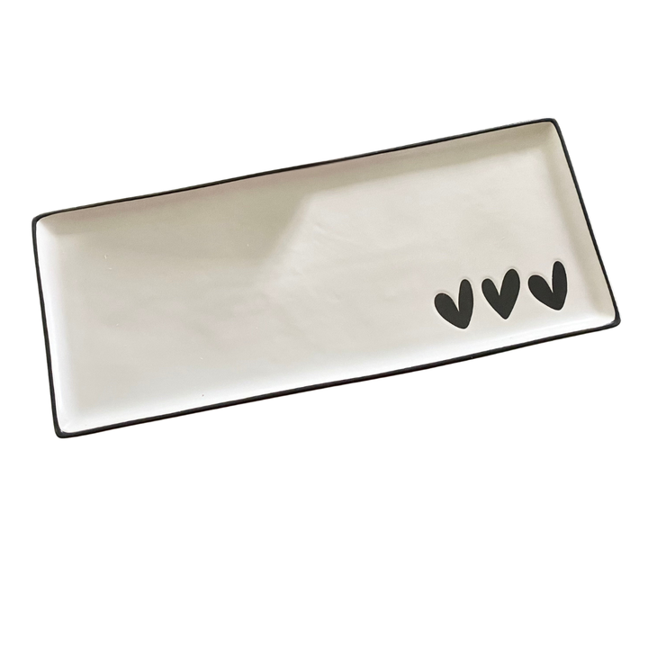 Rectangular ceramic tray with black heart design on a white background