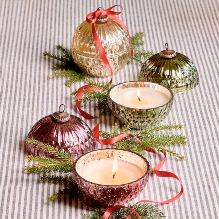 Decorative candles and ornaments on a striped fabric background