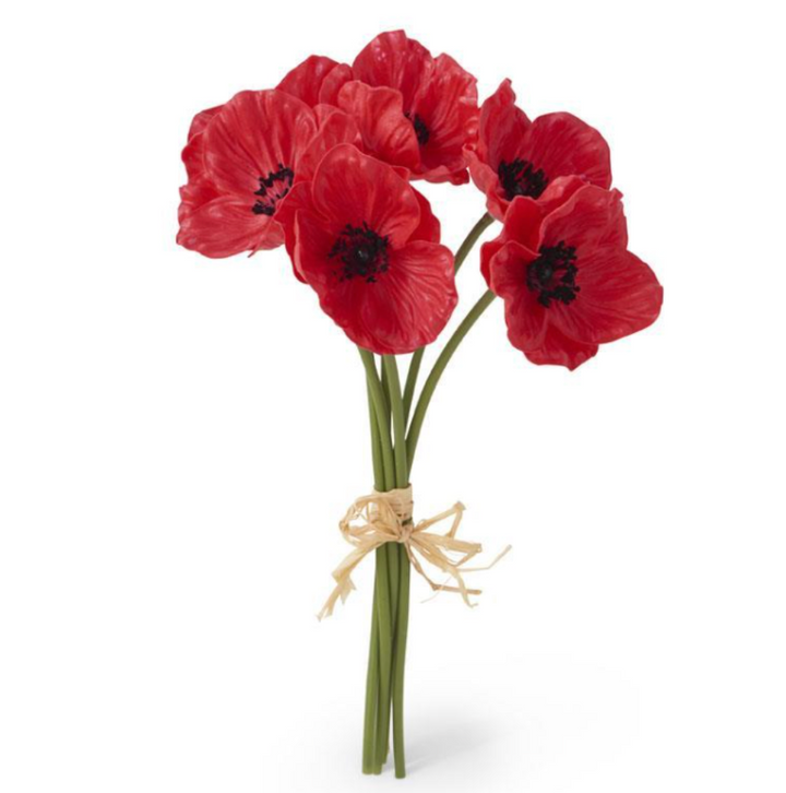 A bouquet of artificial red poppy flowers tied together with raffia against a white background.