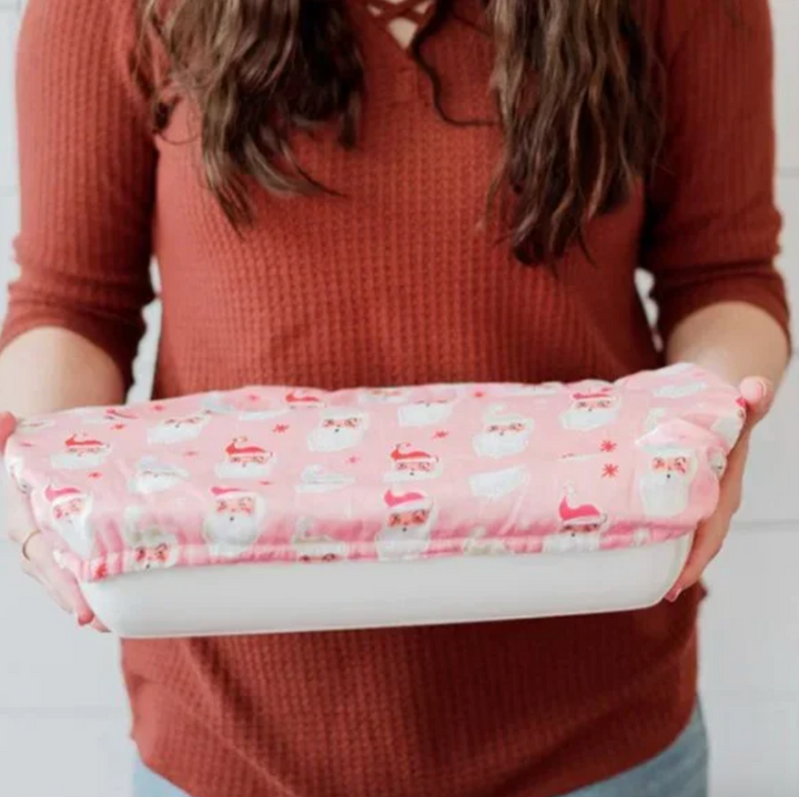 Person holding a pink Reusable Holiday Fabric Bowl Cover with Santa designs on a plain background