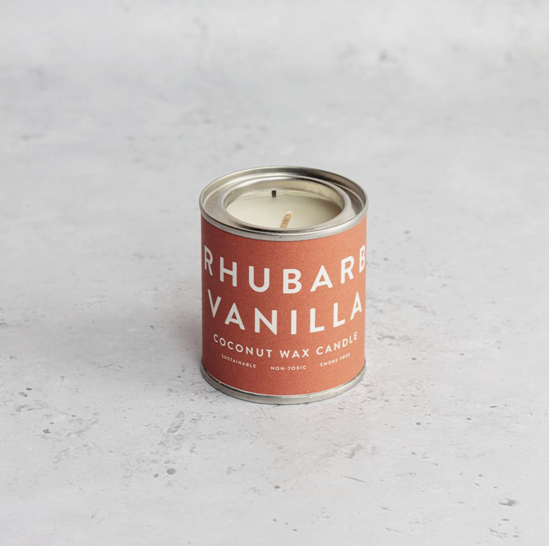 A collection of Conscious Coconut Wax Candles in various colors, displayed in reusable and recyclable paint tins.