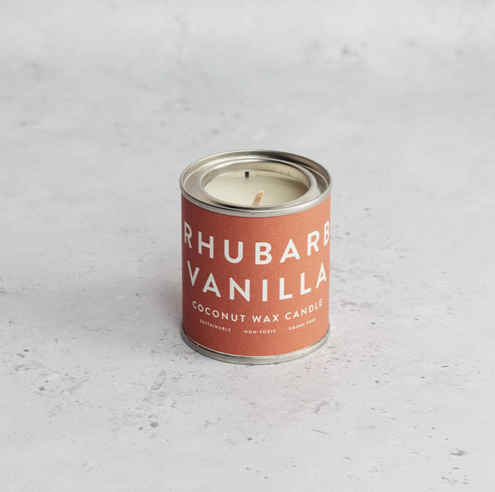 A collection of Conscious Coconut Wax Candles in various colors, displayed in reusable and recyclable paint tins.