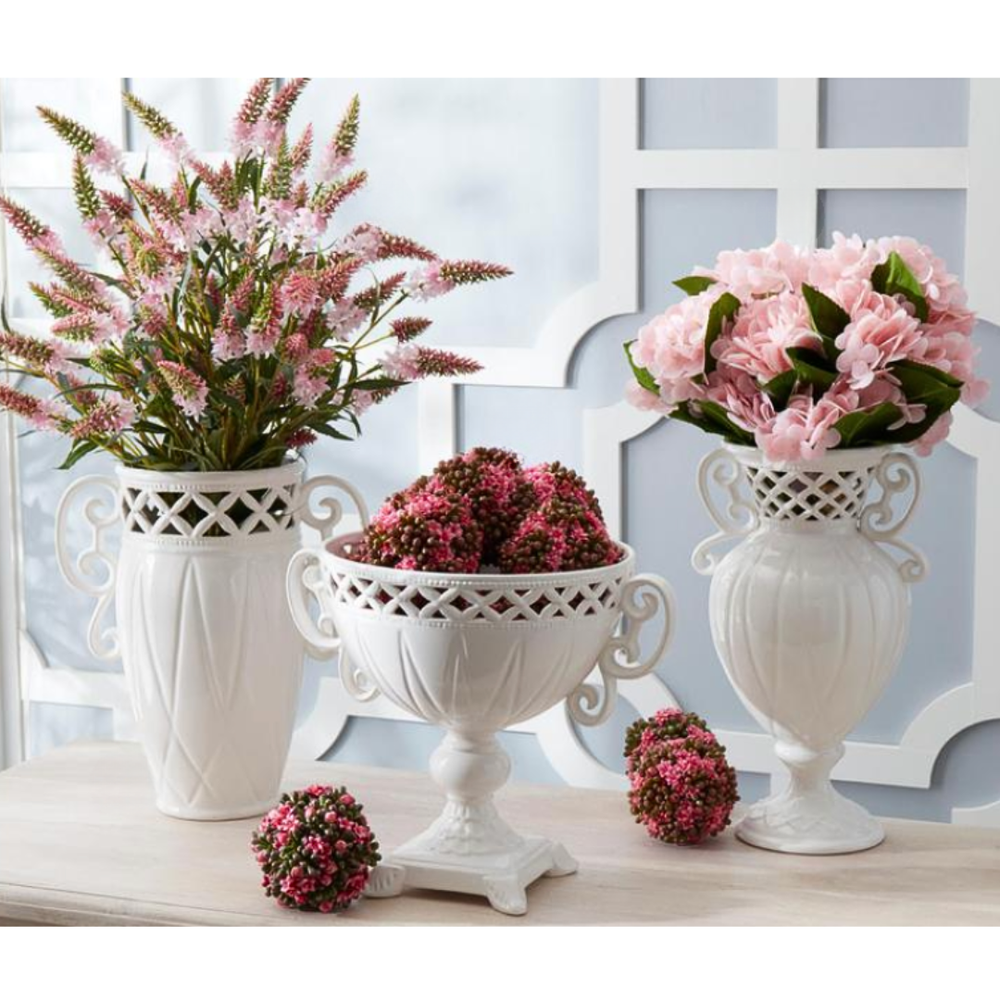 Decorative vases with pink Kalanchoe flowers and plants on a light surface.