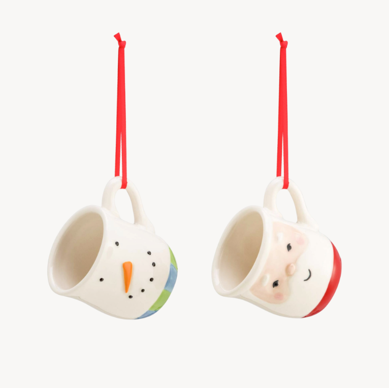 Two coffee pod mug ornaments, one designed like a Santa and the other like a snowman, with red hanging strings.