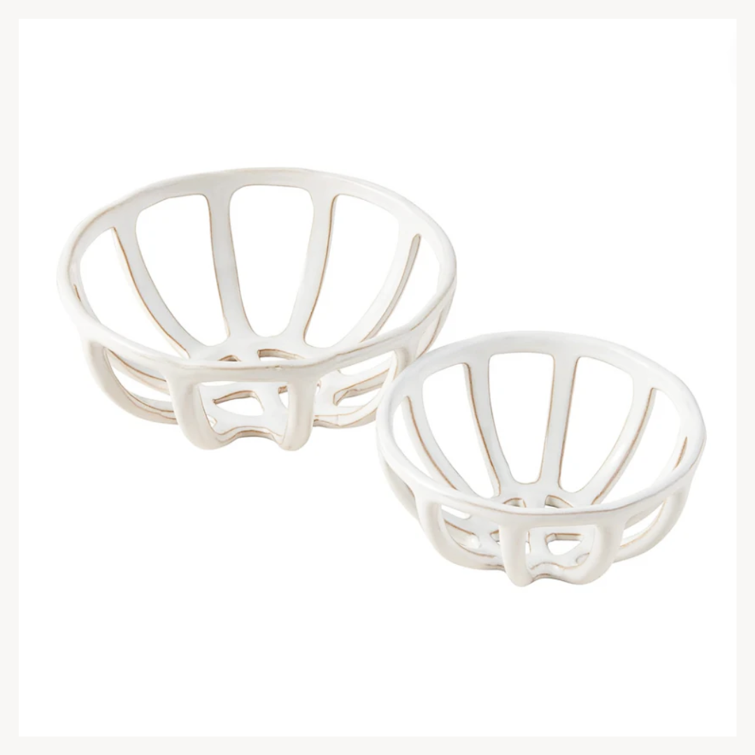 A set of two white terracotta fruit baskets of different sizes with a solid pattern and reactive glaze finish.