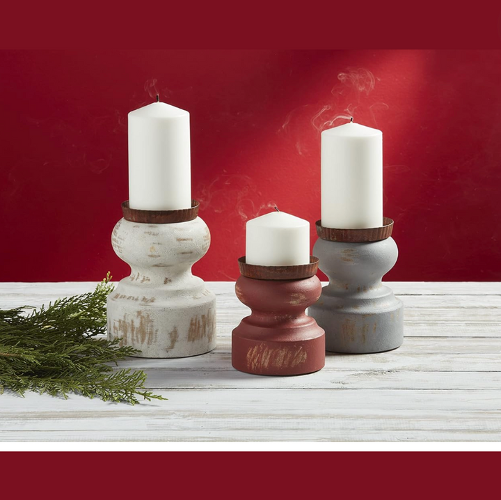Set of three rustic style candle stands in white, gray, and red colors, made of mango wood, displayed with candles on a white surface with a red background.