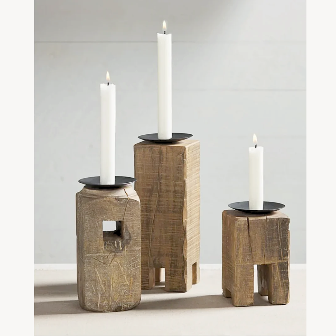 A set of three reclaimed block candle holders in various sizes, made of mango wood with metal sconces, each holding a white candle.