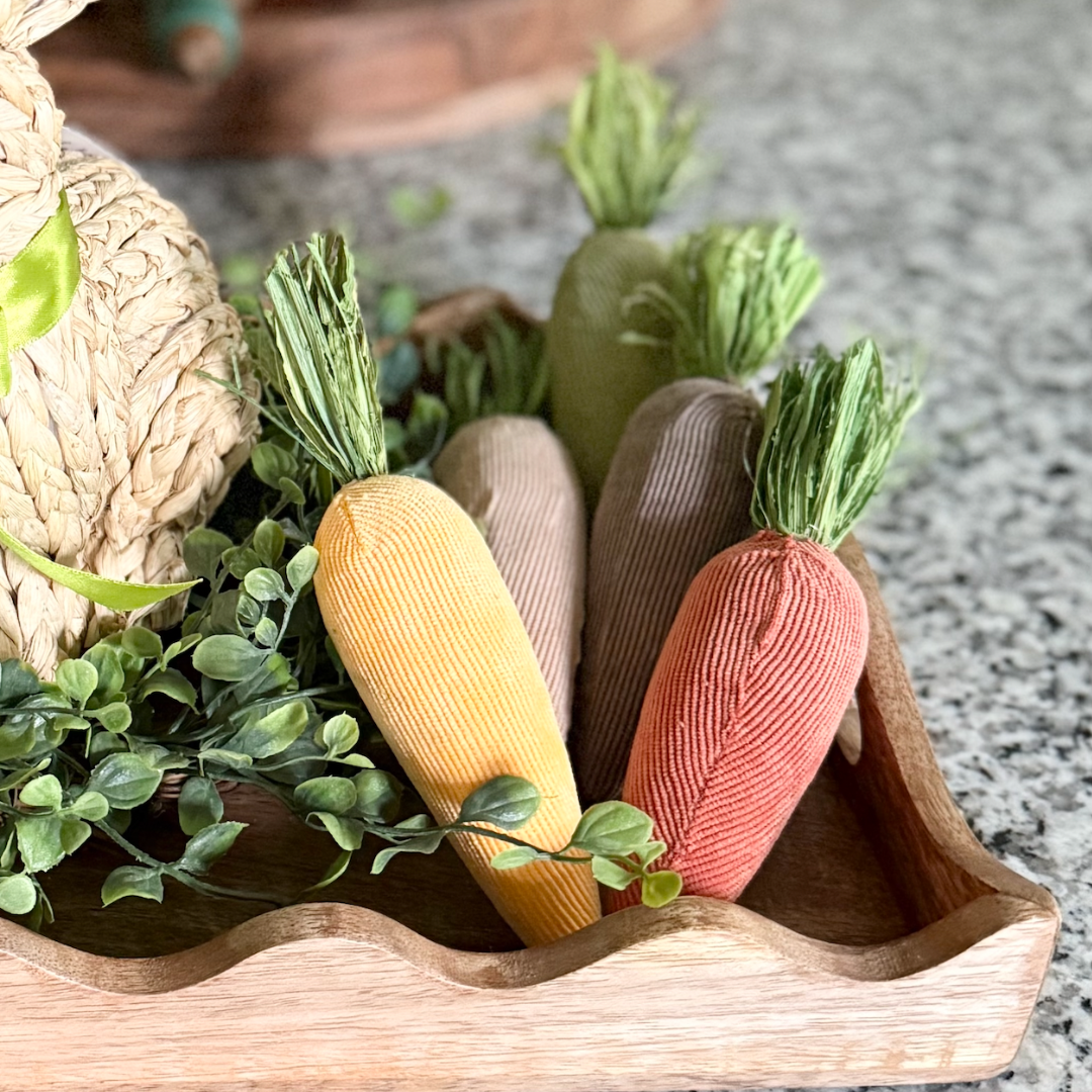 Set of 5 colorful carrot-shaped decor in a wooden basket with green leaves.