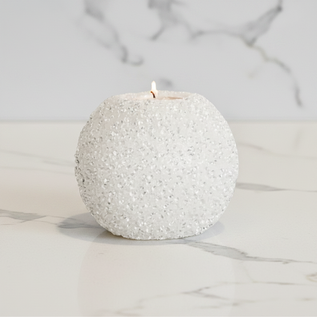 Textured white candle on a marble surface