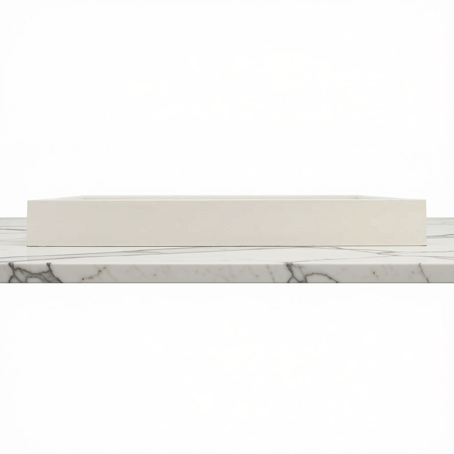 A rectangular white tray with a smooth matte finish, shown from a side angle resting on a white marble surface with gray veining against a white background.