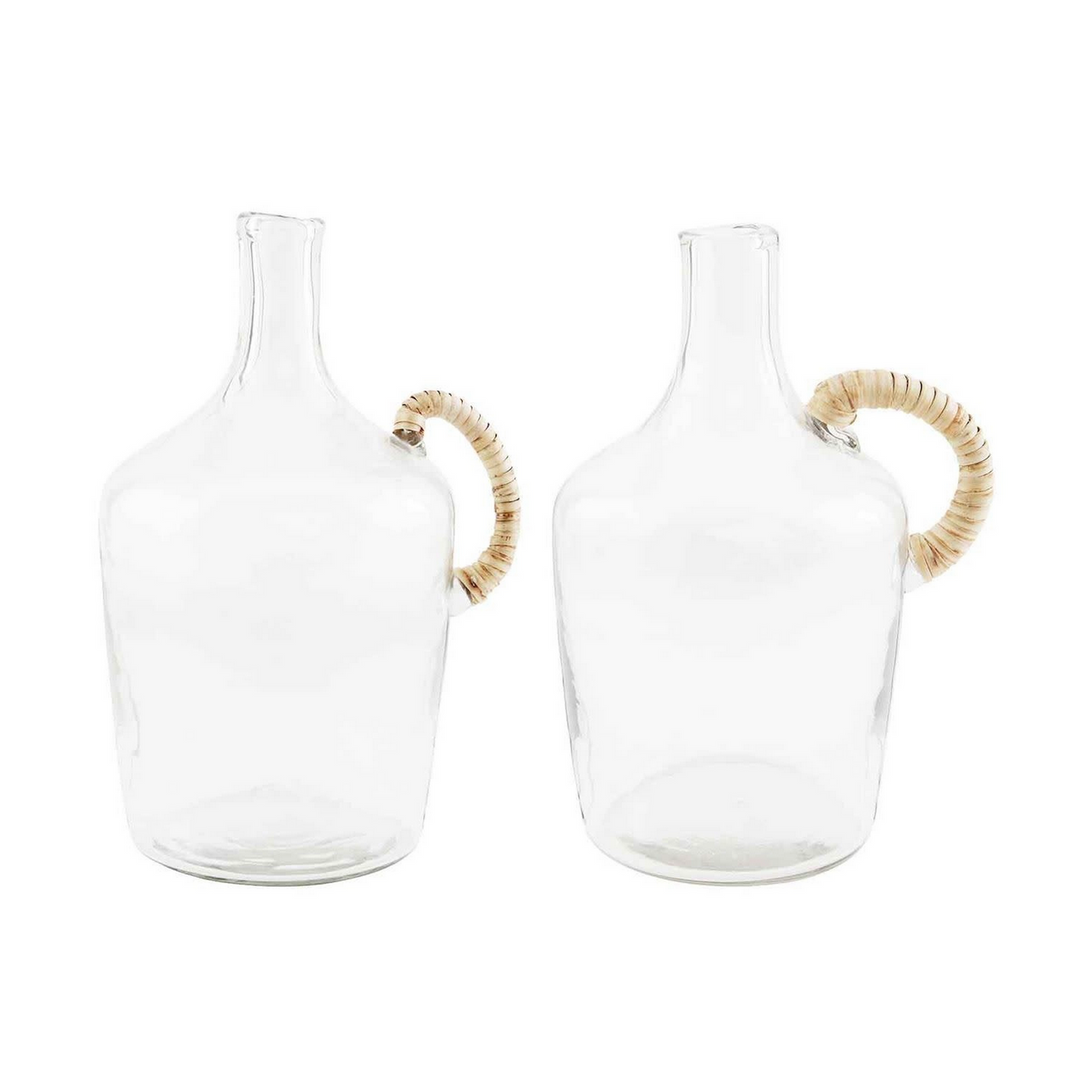 Two clear glass carafes with woven handles on a white background
