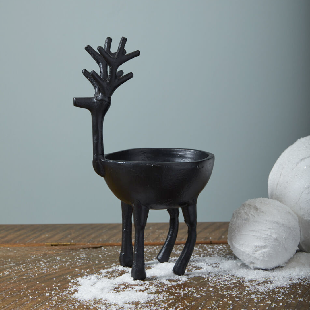 Black reindeer-shaped bowl on a wooden surface with a light gray background