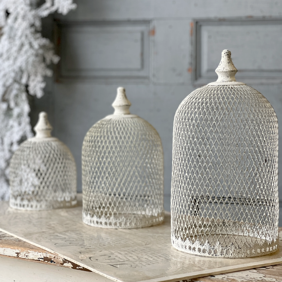 Decorative metal domes on a wooden surface with a gray wall background