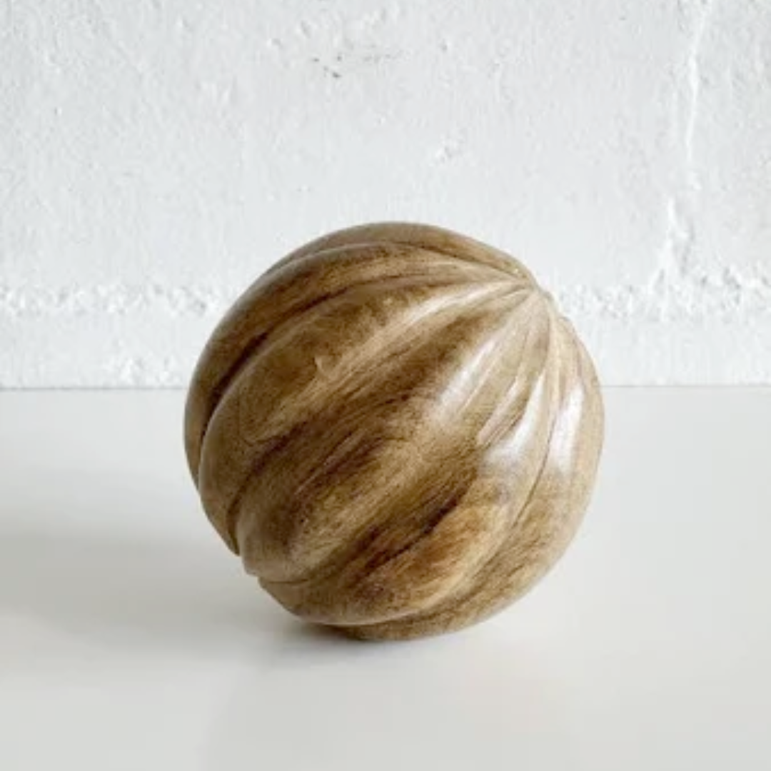 Wooden ball with a striped pattern on a white background