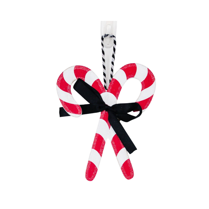 Two red and white striped candy canes tied together with a black ribbon on a white background.