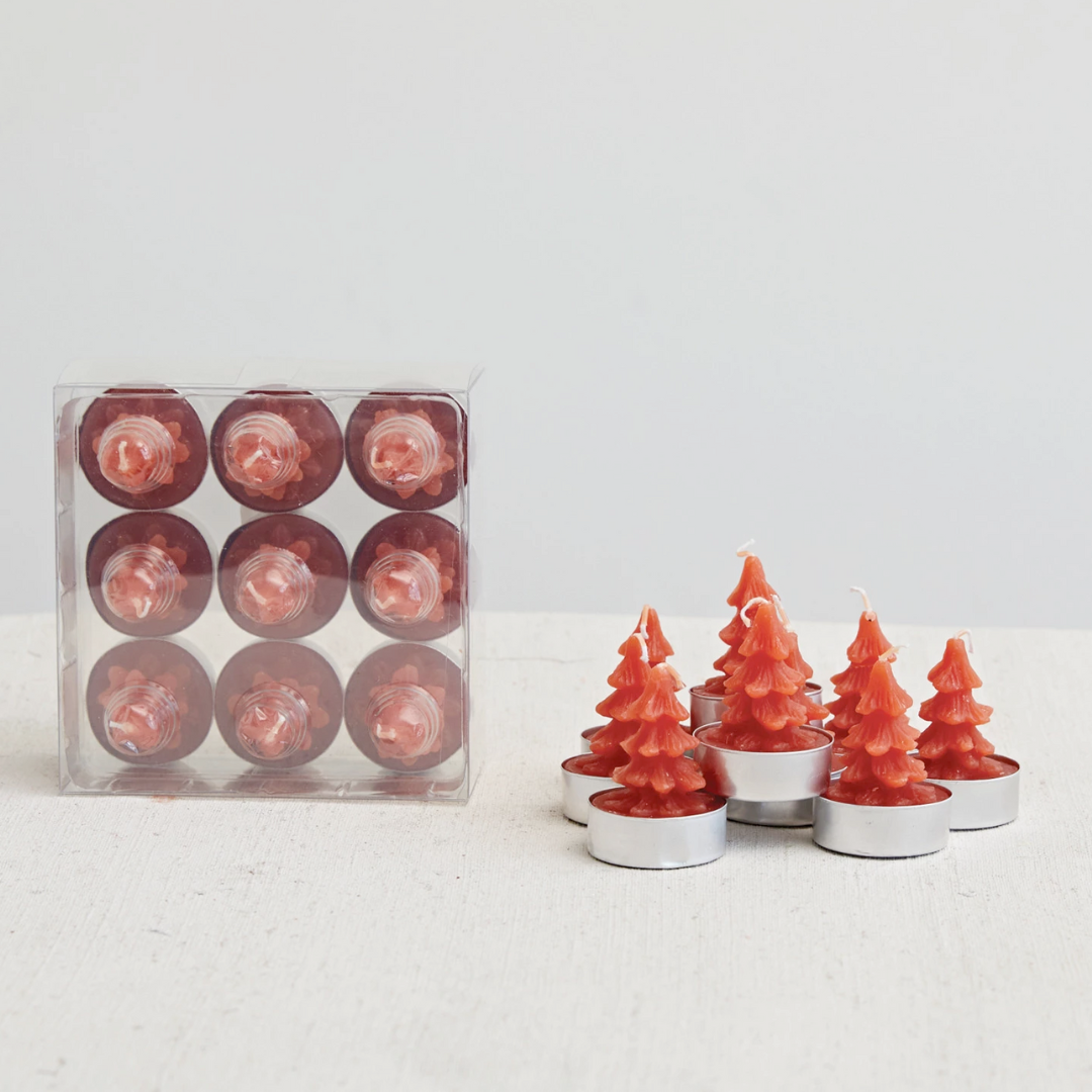 A set of nine red tealight candles shaped like Christmas trees, displayed in a clear box and in metal holders.