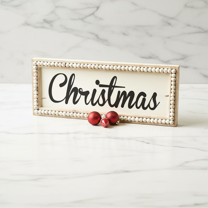 Decorative sign with 'Christmas' text on a marble surface