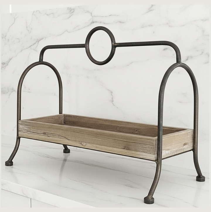 A rustic metal and wood display tray with a dark iron frame featuring a circular top detail and four legs, set against a white marble background.
