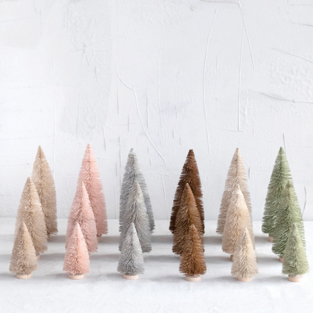 A collection of artificial sisal bottle brush trees in various colors placed on a white surface.