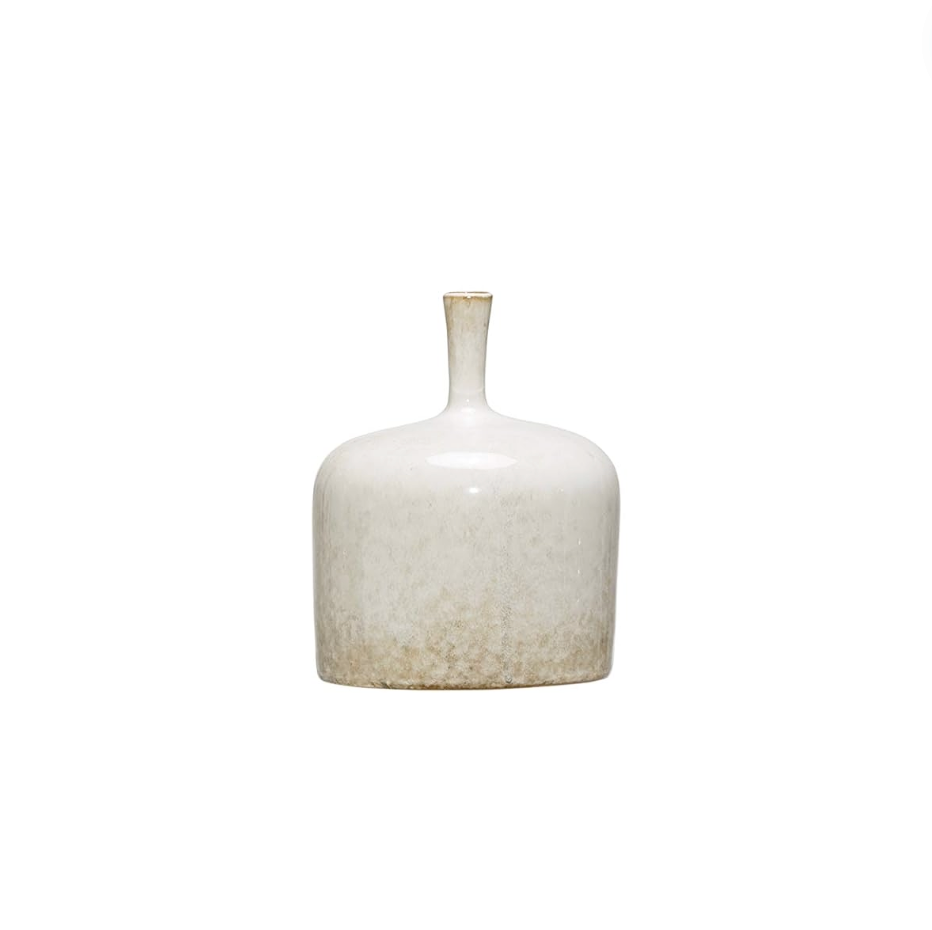 Three white stoneware vases of varying sizes arranged on a wooden surface, with the topmost vase containing a sprig of greenery.