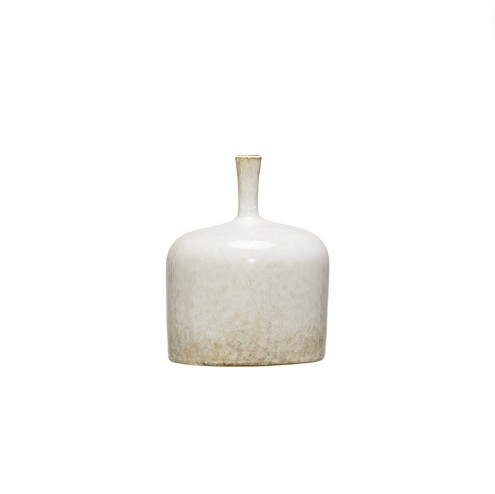 Three white stoneware vases of varying sizes arranged on a wooden surface, with the topmost vase containing a sprig of greenery.