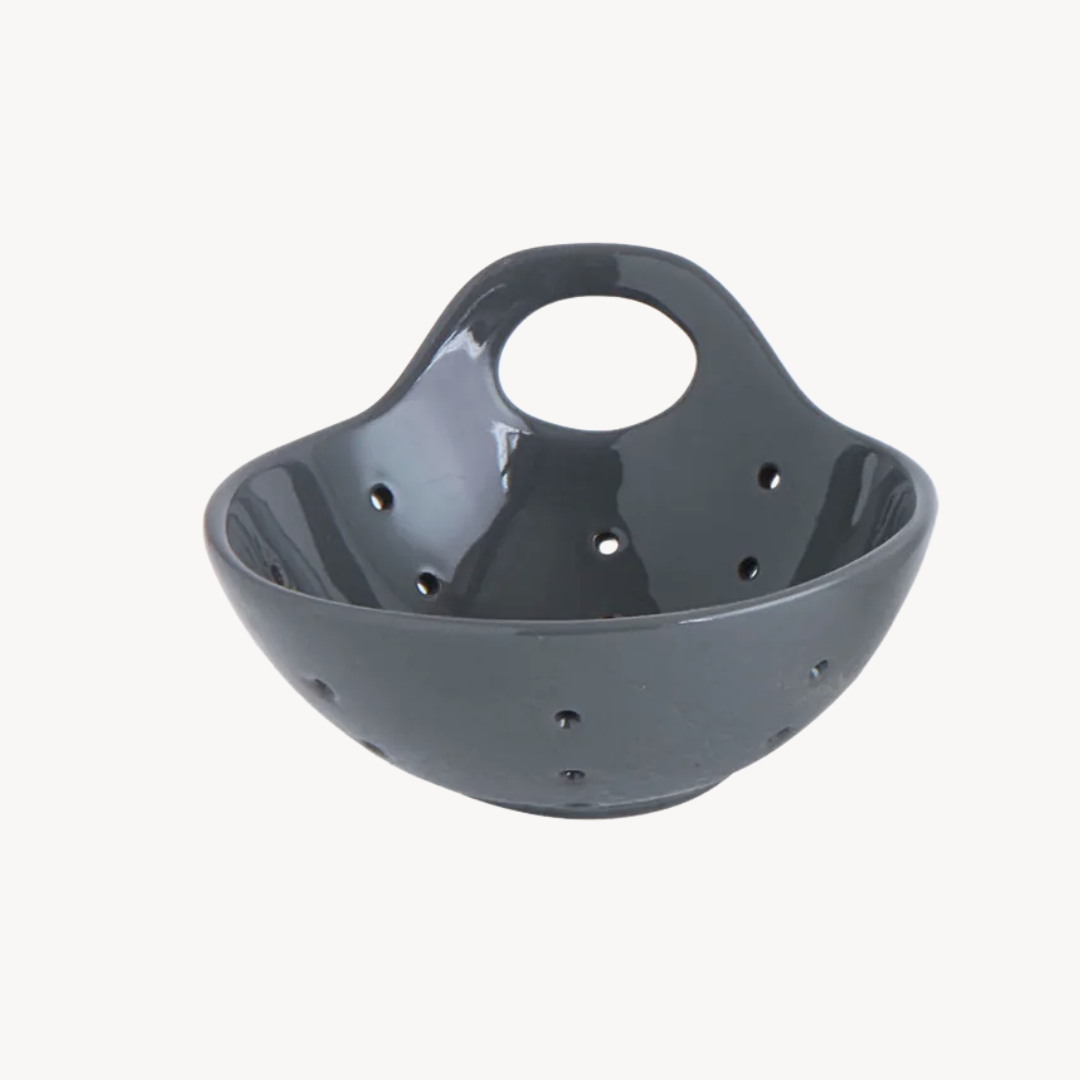 Gray stoneware colander with handles on a white background