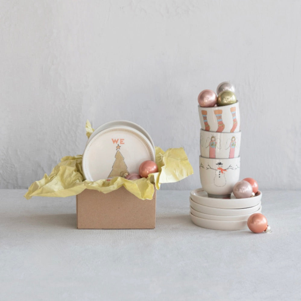 A set of stoneware holiday dishes including 8 cups and 8 plates with hand-painted Christmas icons.