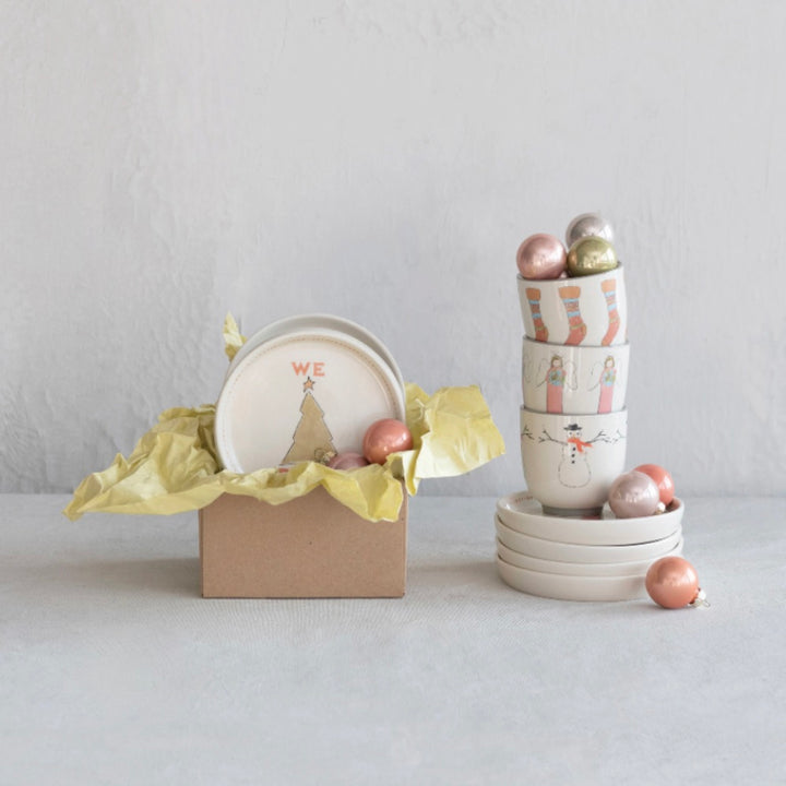 A set of stoneware holiday dishes including 8 cups and 8 plates with hand-painted Christmas icons.