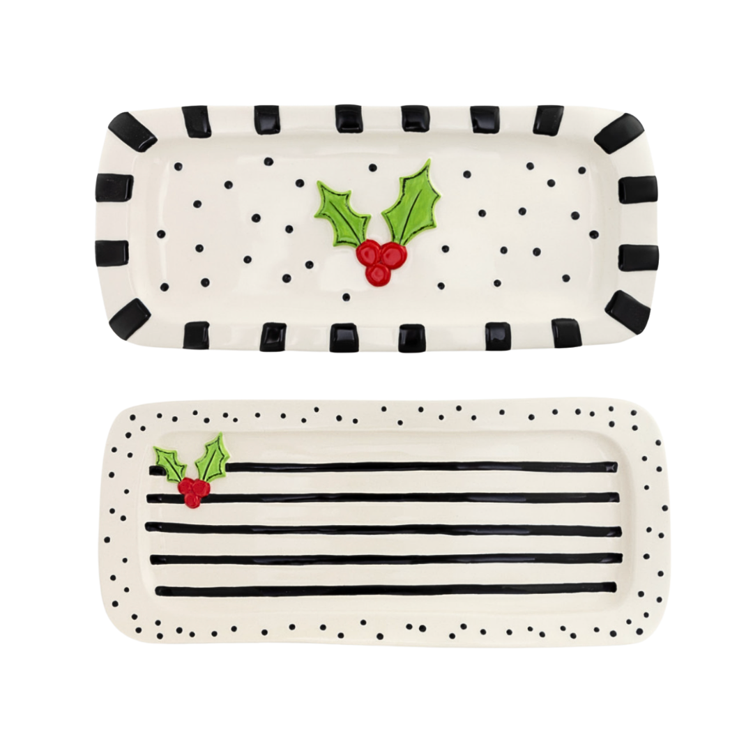 Two decorative trays with black polka dot and striped patterns and holly design on a white background.