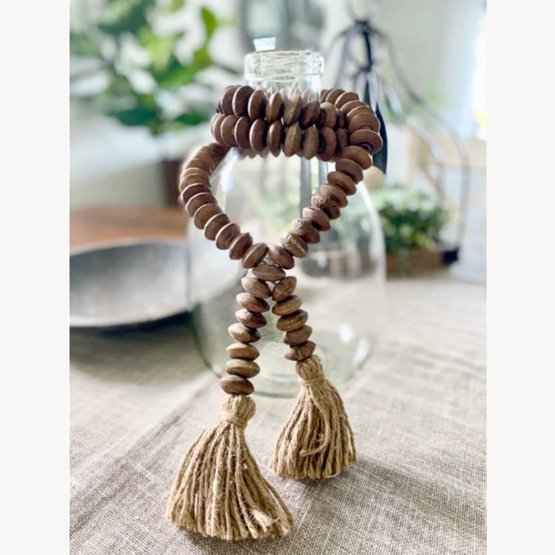 Decorative item with wooden beads and tassels on a table
