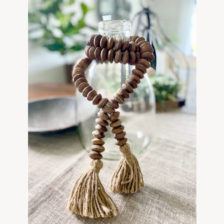 Decorative item with wooden beads and tassels on a table