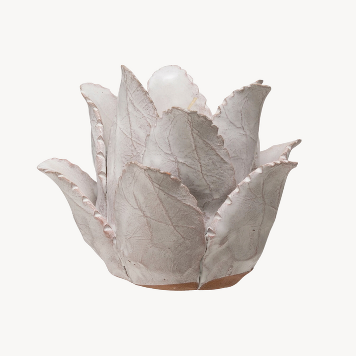 A handcrafted terracotta flower-shaped tea light holder with a painted distressed glossy finish.