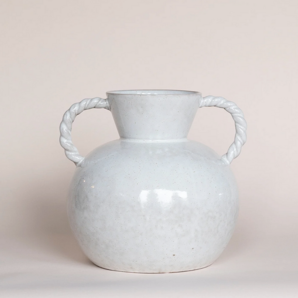 A white stoneware vase with twisted handles on a neutral background.