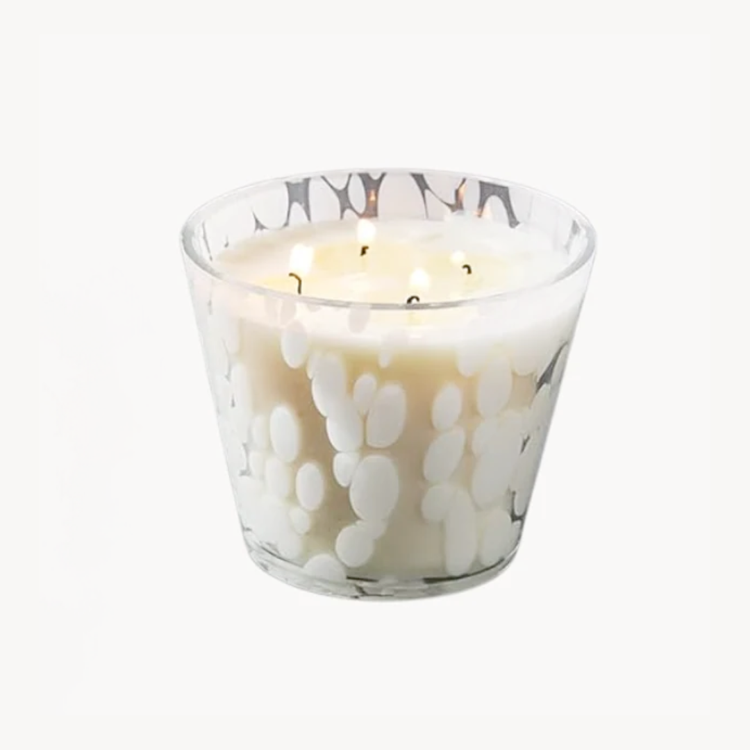 Glass candle with white paw print design on a white background
