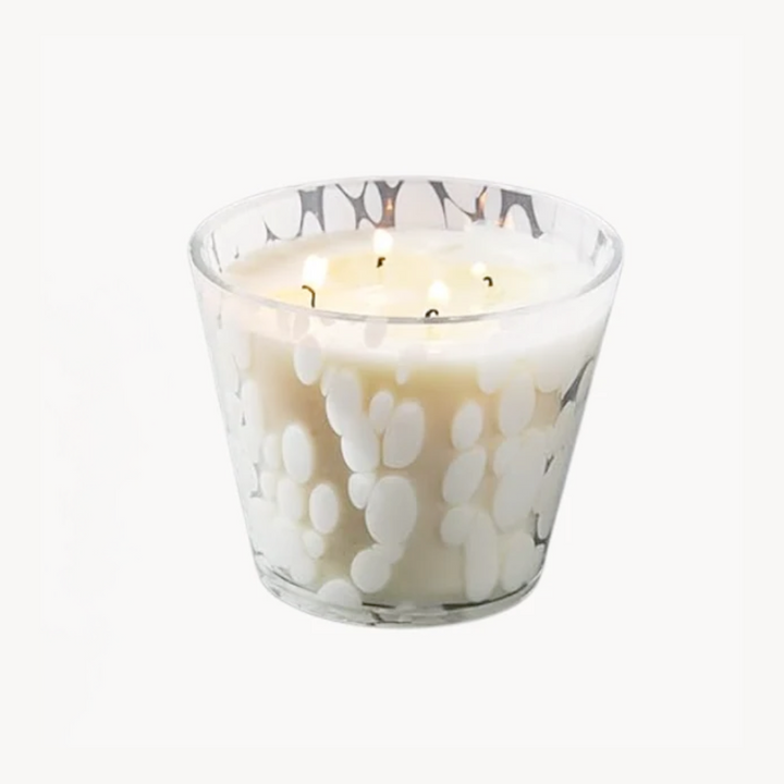 Glass candle with white paw print design on a white background