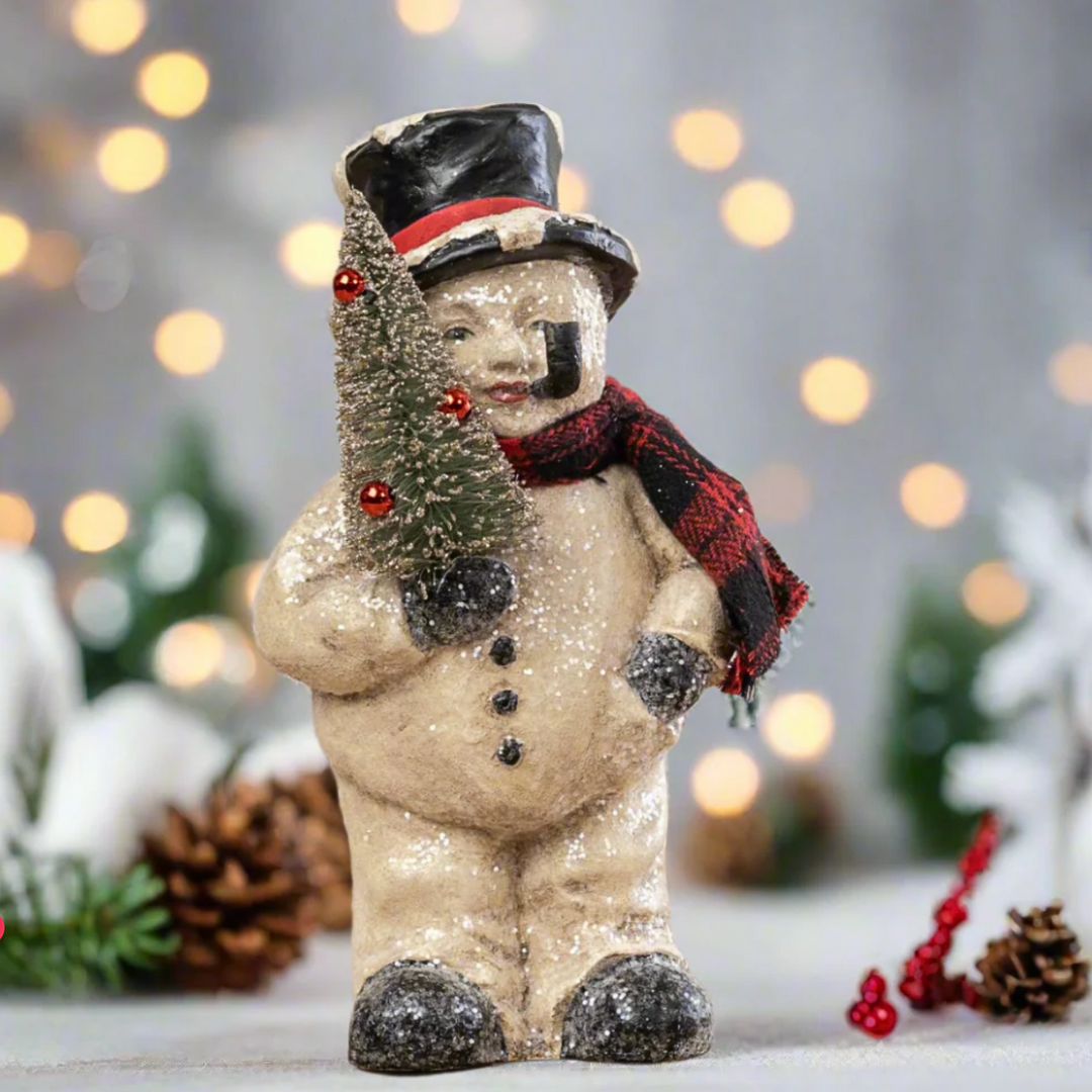 Decorative snowman figurine with a tree on a blurred festive background