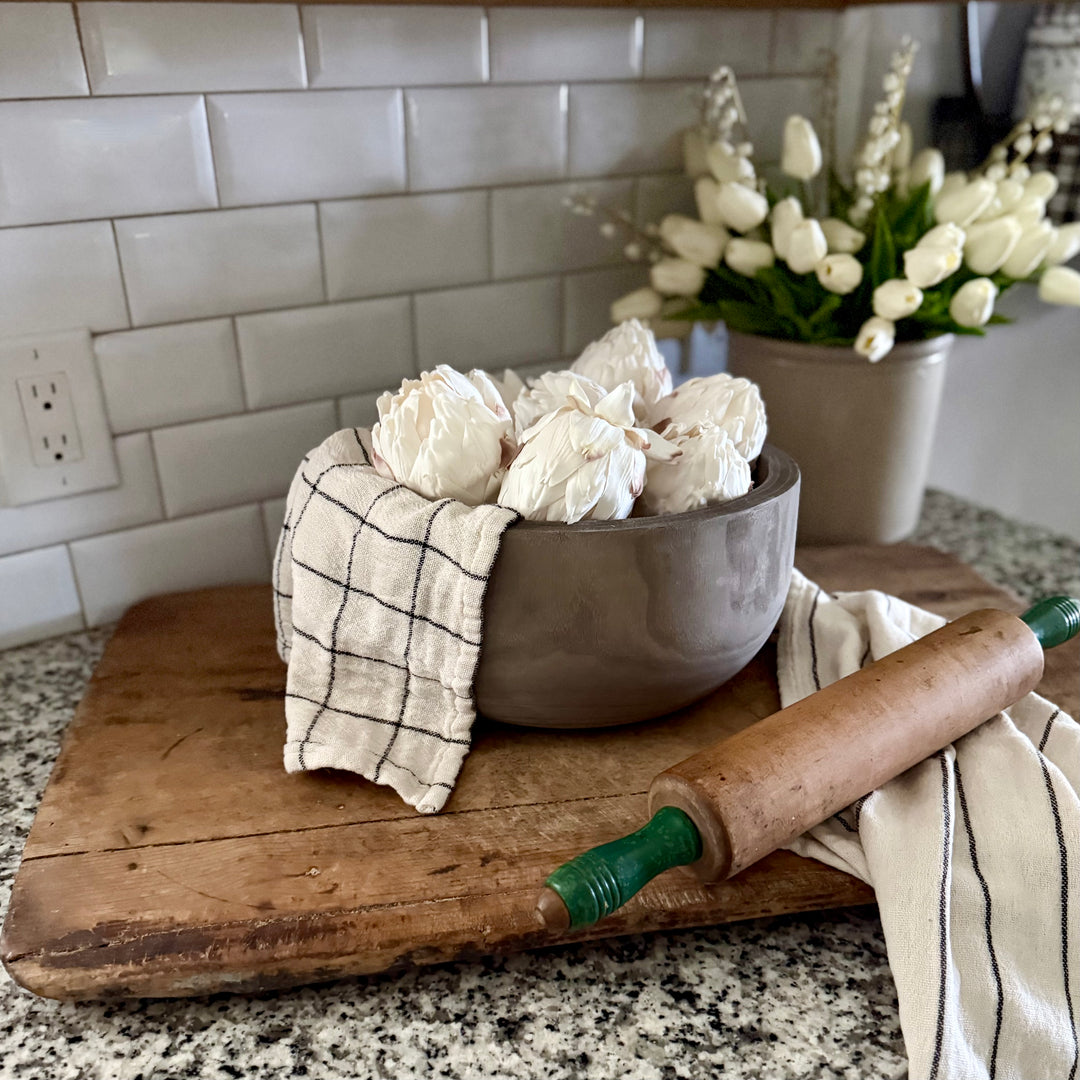 Bowl with white artichokes on a wooden cutting board in a kitchen setting