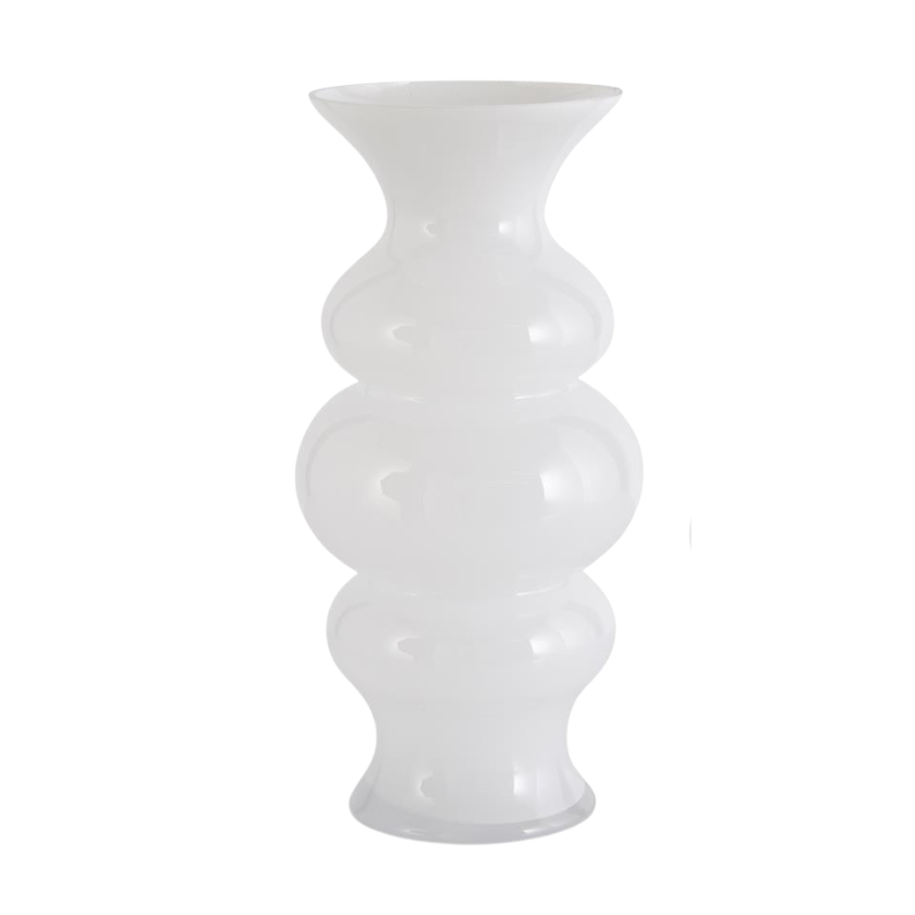 A set of white hourglass fluted glass vases in two sizes displayed on a surface with greenery in the background.